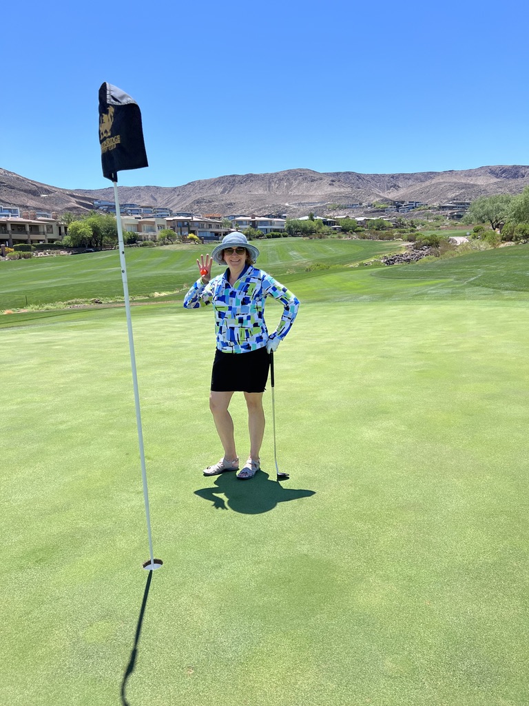 A woman standing on the green holding onto a flag